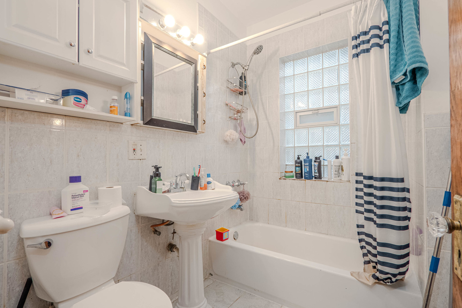 1435 Grove Avenue Berwyn, IL 60402 - Photo 8 of 25 a bathroom with a sink a toilet and shower curtain