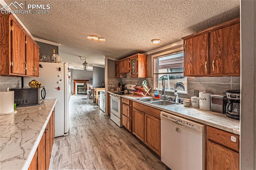 36 Valley Circle Guffey, CO 80820 - Photo 20 of 40 a kitchen with stainless steel appliances granite countertop wooden cabinets a refrigerator a sink a stove and a center island with wooden floor