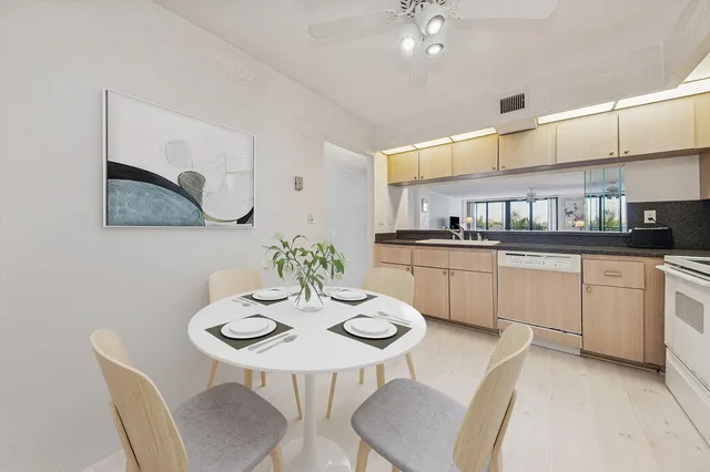 a kitchen with granite countertop white cabinets and chairs