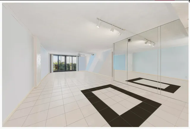 a view of an empty room with window and a ceiling fan