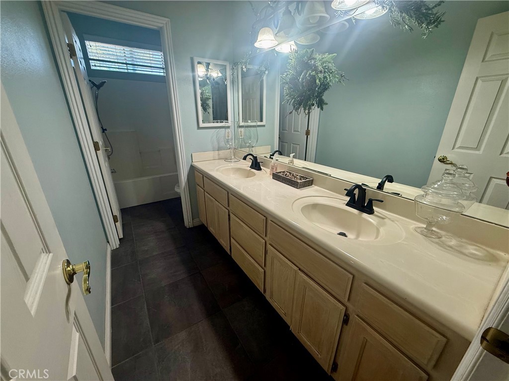 9869 Kehl Canyon Road Cherry Valley, CA 92223 - Photo 21 of 27 a bathroom with a double vanity sink and mirror with shower