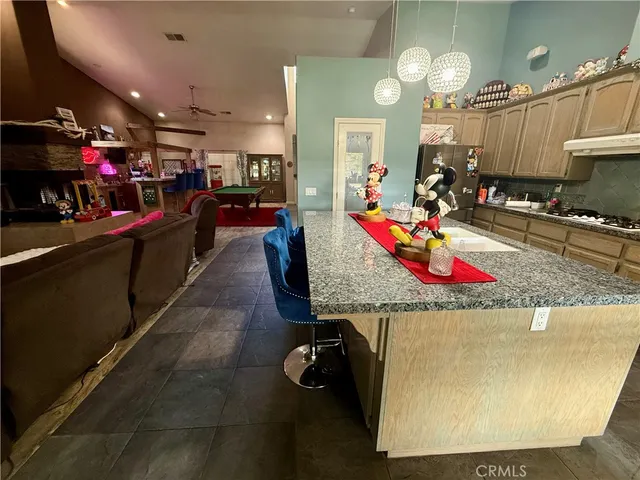 a kitchen area with granite countertop lots of clutter and stainless steel appliances