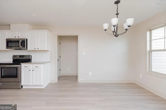 a view of kitchen with granite countertop stainless steel appliances a stove and a window