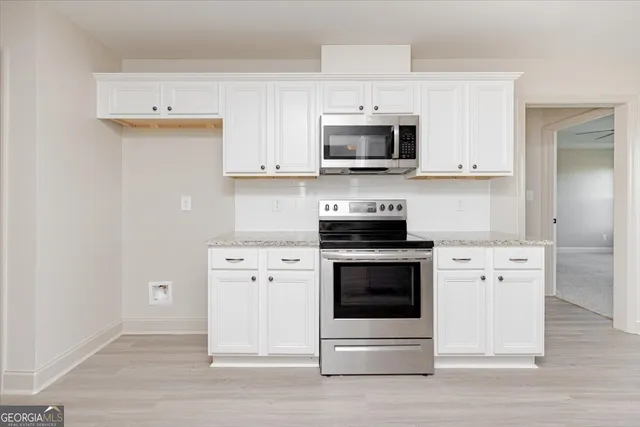 a kitchen with white cabinets and stainless steel appliances