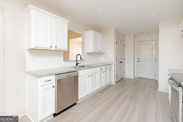 a kitchen with a sink cabinets stainless steel appliances and a window