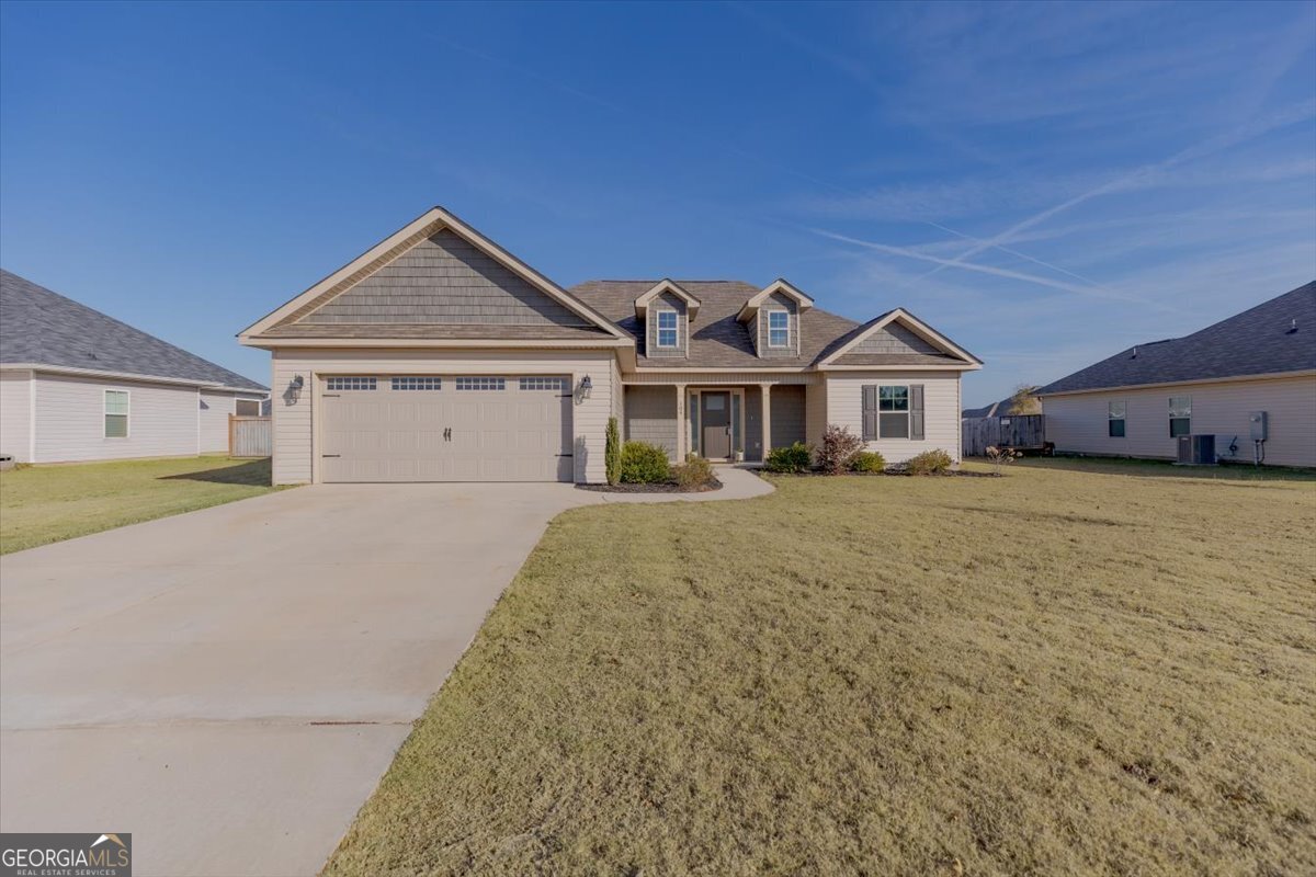 104 Gunner Lane Perry, GA 31069 - Photo 2 of 48 a view of a white house next to a yard with large trees
