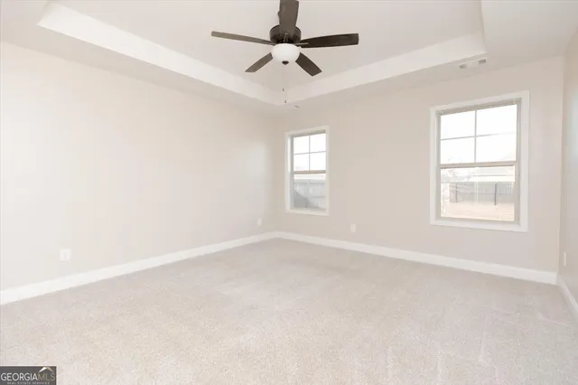 an empty room with a window and a fan