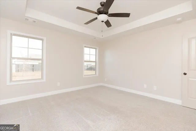 an empty room with a window and a fan