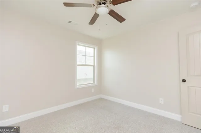 an empty room with a window and a fan