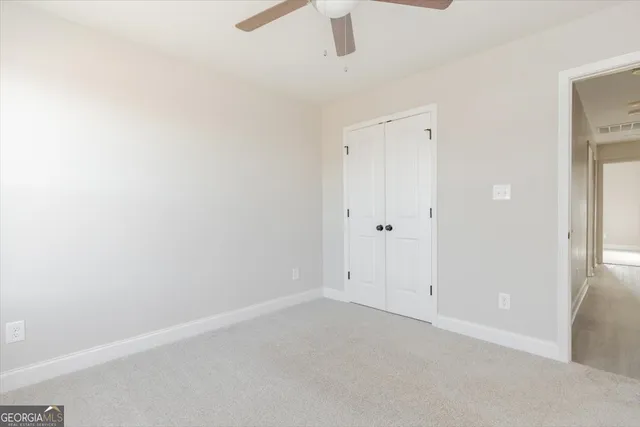 an empty room with a ceiling fan and window