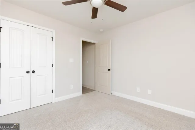 an empty room with a ceiling fan and window