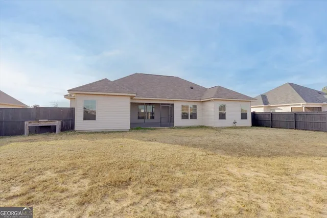 a view of a yard in front of a house with a large tree