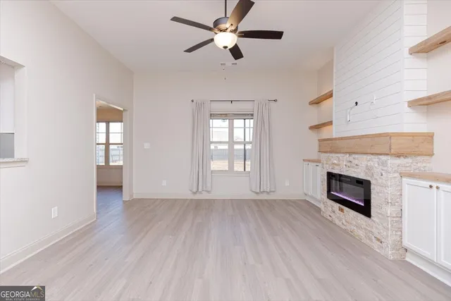 wooden floor fireplace and windows in an empty room