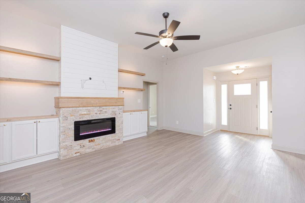 104 Gunner Lane Perry, GA 31069 - Photo 9 of 48 an empty room with wooden floor fireplace and windows