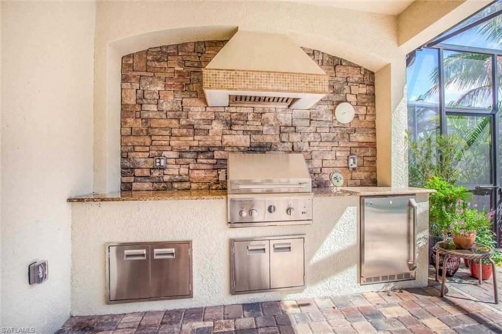 9526 Piacere Way Naples, FL 34113 - Photo 19 of 25 a kitchen with stainless steel appliances granite countertop a stove and a refrigerator