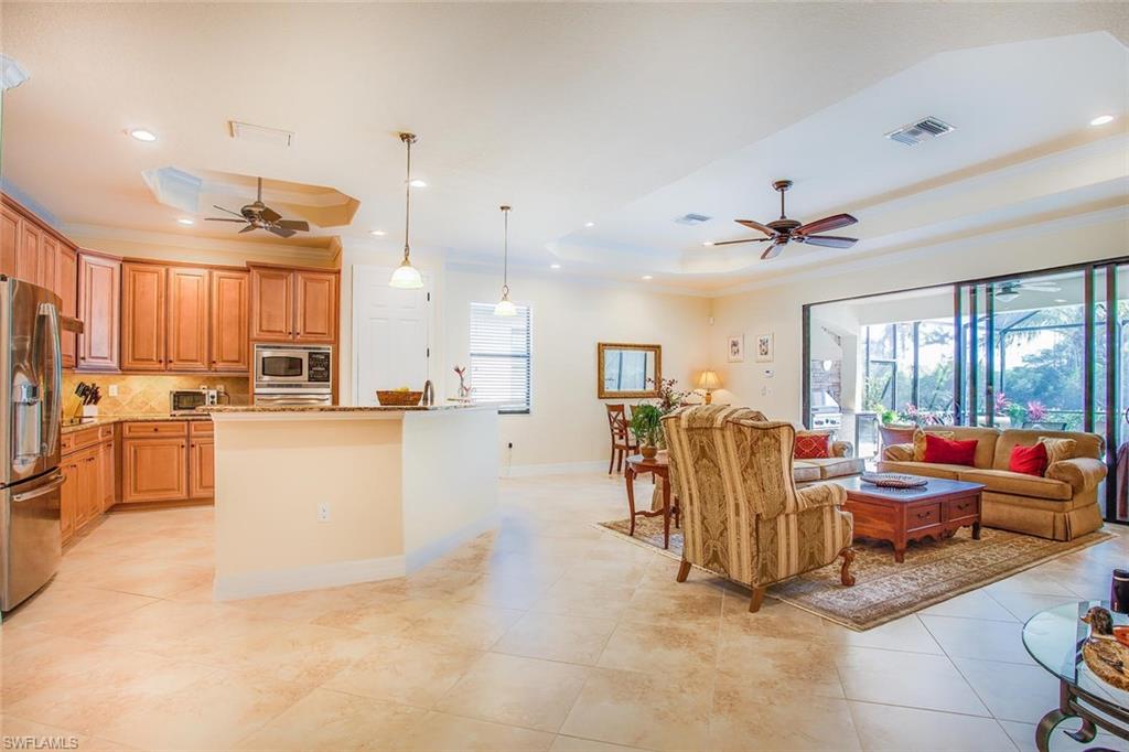 9526 Piacere Way Naples, FL 34113 - Photo 3 of 25 a living room with couches and kitchen view with wooden floor