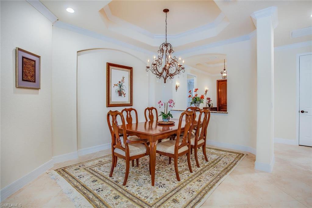 9526 Piacere Way Naples, FL 34113 - Photo 10 of 25 a dining room with furniture a rug and a chandelier