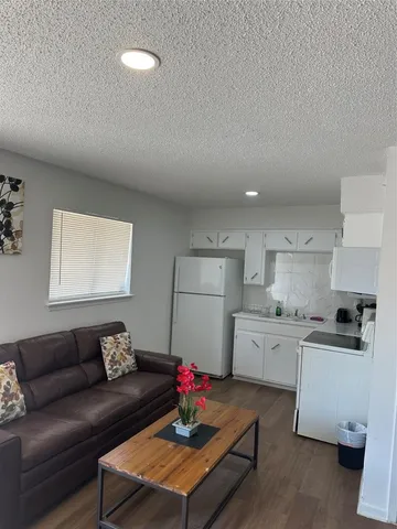 a living room with furniture and kitchen view