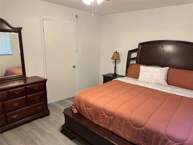 a bedroom with a bed and a flat tv screen on a dresser