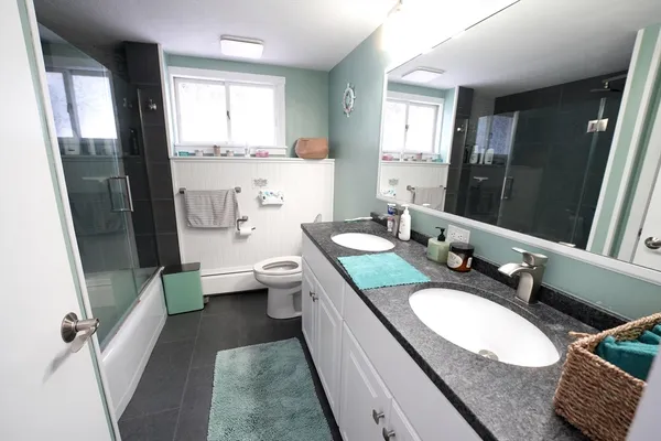 a bathroom with a granite countertop sink mirror vanity and toilet
