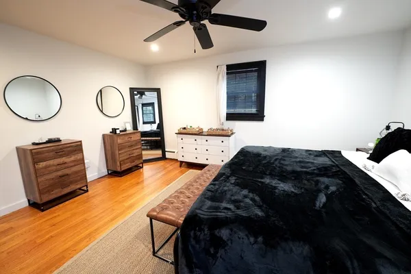 a bedroom with bed and wooden floor