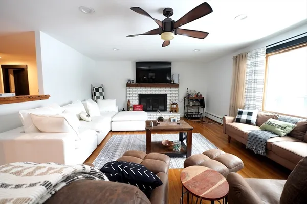 a living room with furniture a flat screen tv and a fireplace