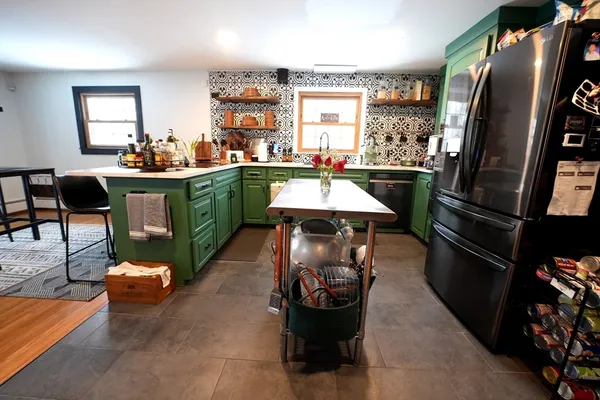 a kitchen with stainless steel appliances kitchen island granite countertop a refrigerator a stove a sink and a dining table with the view of living room