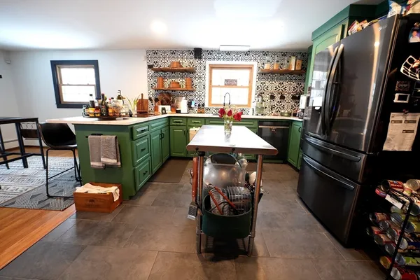 a kitchen with stainless steel appliances kitchen island granite countertop a refrigerator a stove a sink and a dining table with the view of living room