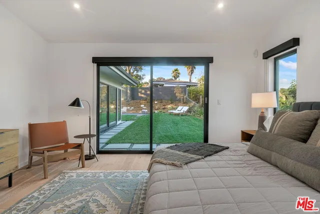 a living room with furniture floor to ceiling window and a floor to ceiling window