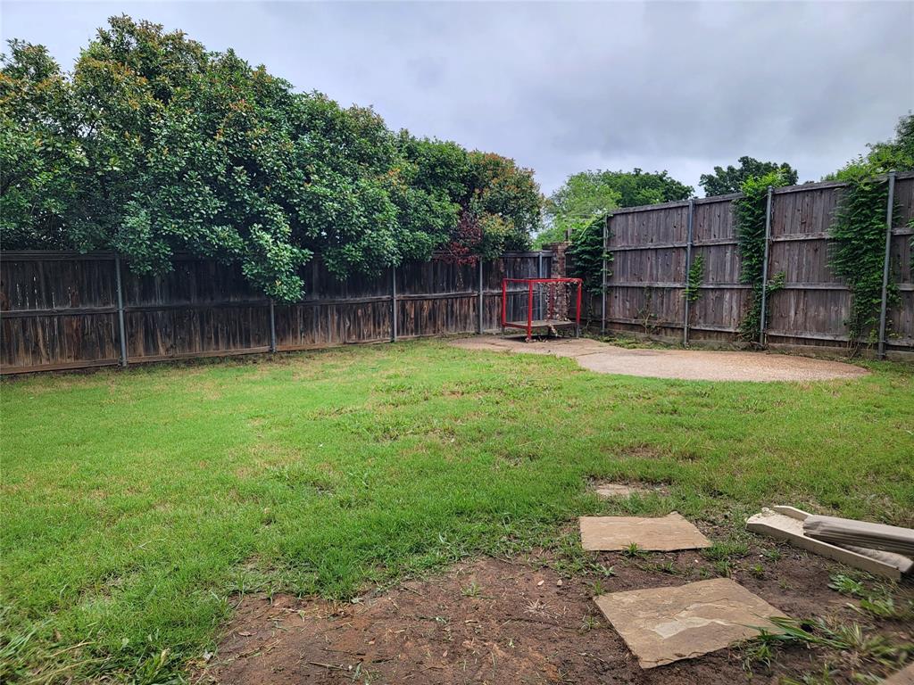 1604 Knoll Ridge Circle Corinth, TX 76210 - Photo 33 of 37 Expansive backyard featuring a lush lawn, privacy fencing, mature trees, and a concrete patio