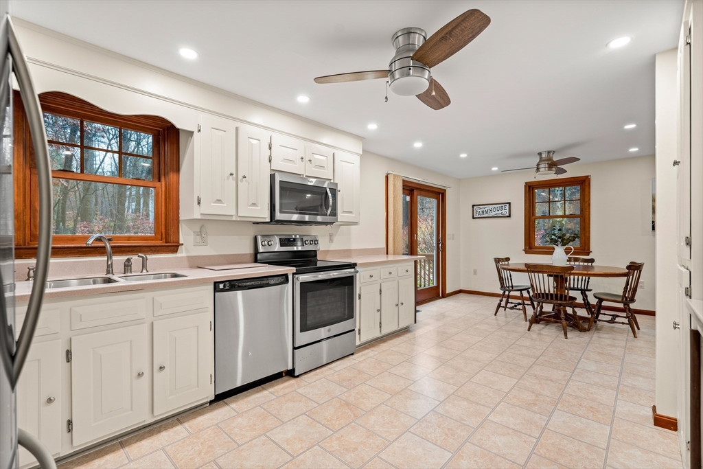 91 Century Way Dunstable, MA 01827 - Photo 5 of 31 a kitchen with stainless steel appliances kitchen island granite countertop a stove top oven a sink a dining table and chairs with wooden floor