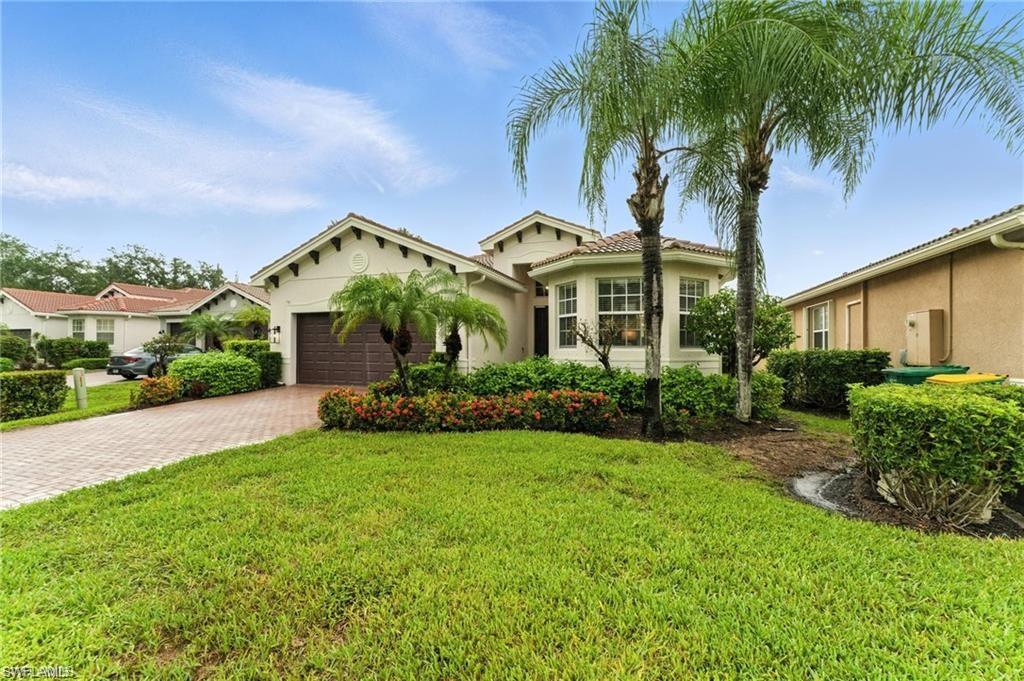 6899 Del Mar Terrace Naples, FL 34105 - Photo 12 of 41 a front view of a house with a yard and palm trees
