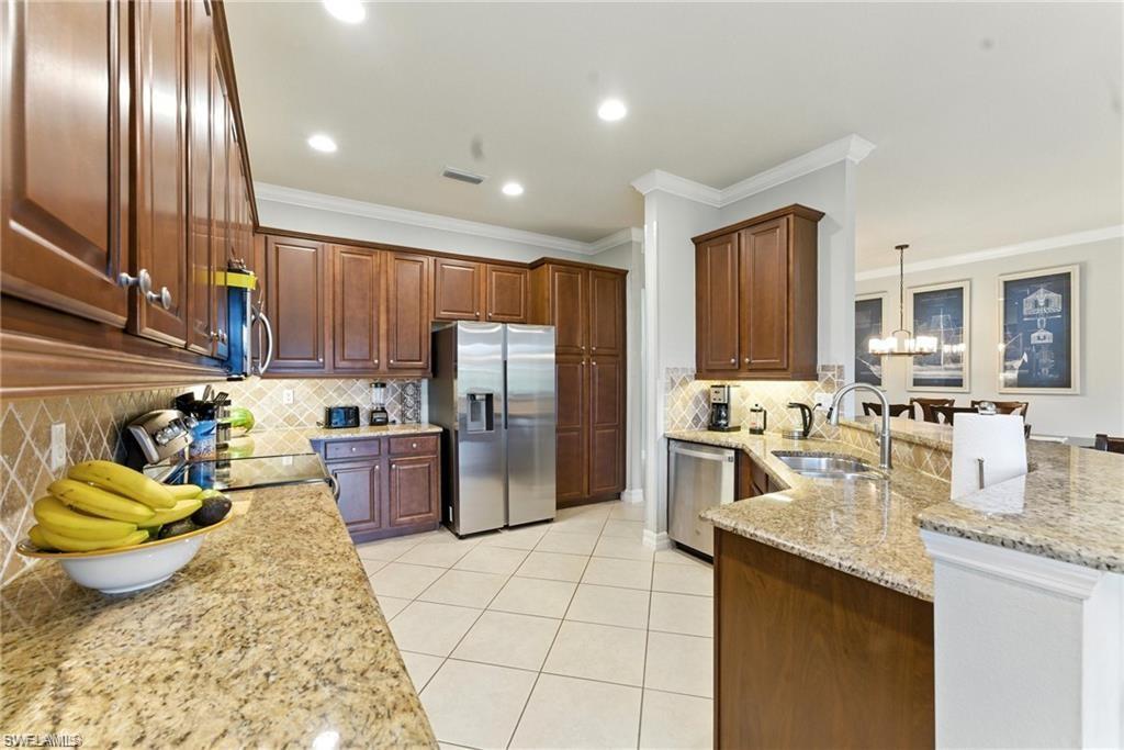 6899 Del Mar Terrace Naples, FL 34105 - Photo 19 of 41 a kitchen with stainless steel appliances granite countertop a sink refrigerator and cabinets