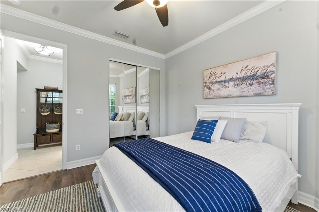 6899 Del Mar Terrace Naples, FL 34105 - Photo 24 of 41 a bedroom with a large bed and a chandelier