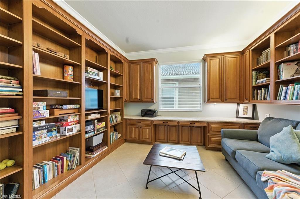 6899 Del Mar Terrace Naples, FL 34105 - Photo 25 of 41 a living room with furniture a rug and a book shelf