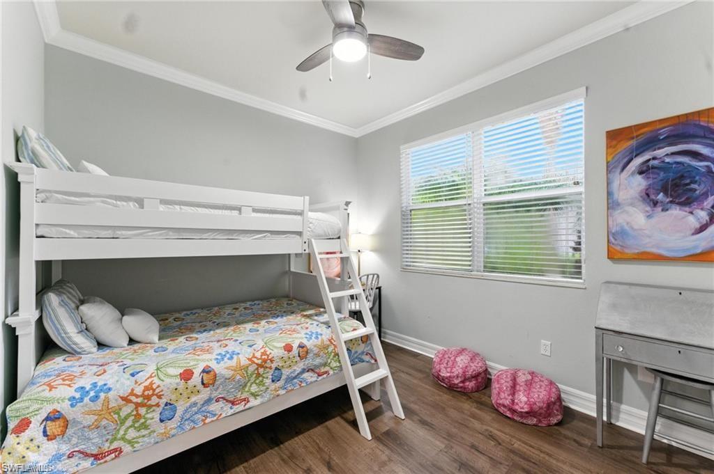 6899 Del Mar Terrace Naples, FL 34105 - Photo 27 of 41 a bedroom with a bed and chandelier