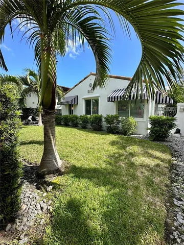 a view of house with swimming pool and porch with green space