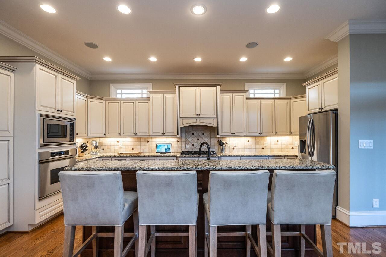 3024 Farrior Road Raleigh, NC 27607 - Photo 11 of 42 a kitchen with granite countertop a center island stainless steel appliances cabinets and a counter top space