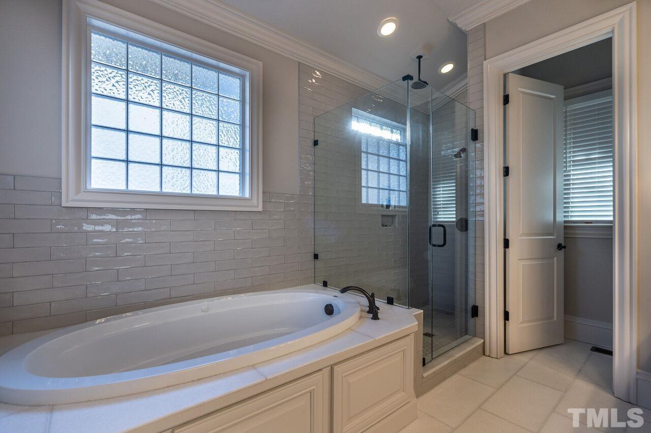 3024 Farrior Road Raleigh, NC 27607 - Photo 23 of 42 a bathroom with a bathtub and a shower
