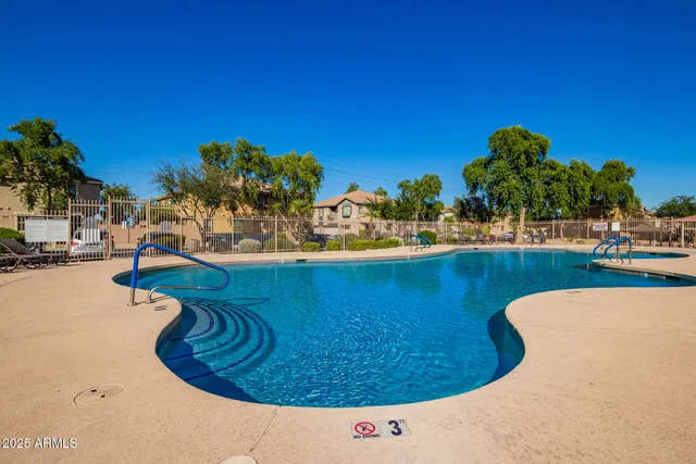 a view of a swimming pool with a house in the background