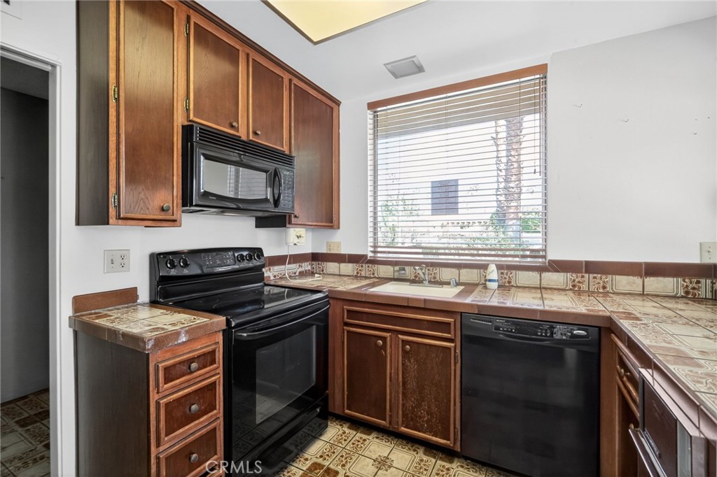 76695 Roadrunner Drive Indian Wells, CA 92210 - Photo 8 of 29 a kitchen with stainless steel appliances granite countertop a stove microwave and sink