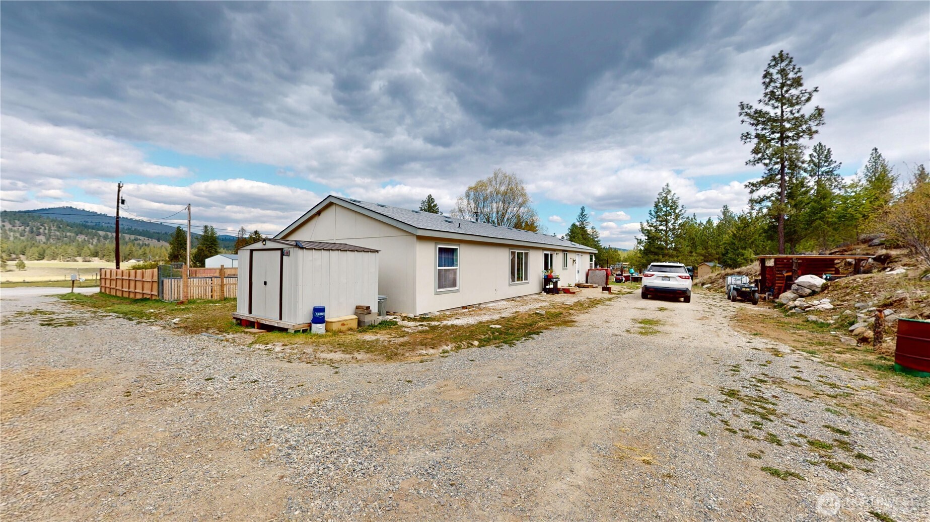 722 Aeneas Valley Road Tonasket, WA 98855 - Photo 30 of 35 a view of a large house with a yard and car parked in front of it