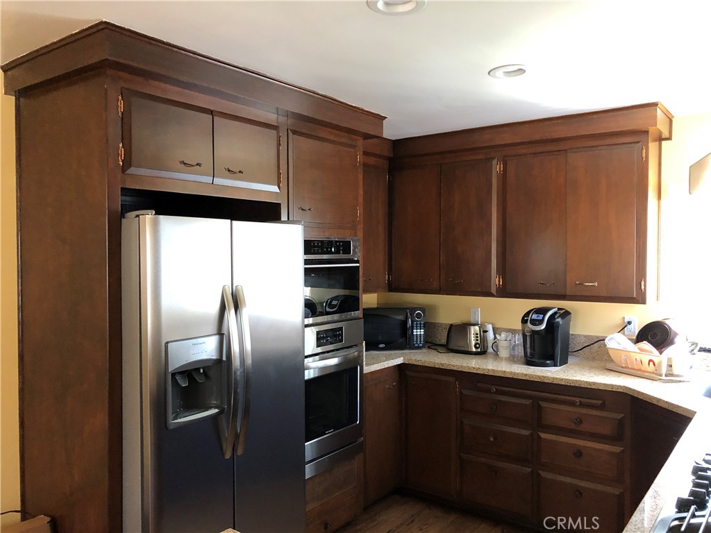 10404 Foothill Boulevard Sylmar, CA 91342 - Photo 7 of 29 a kitchen with stainless steel appliances granite countertop a refrigerator a sink a stove and cabinets