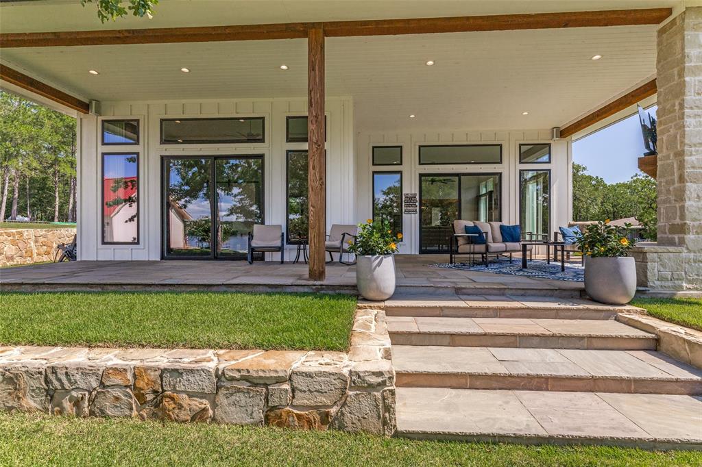 1757 Country Club Road Bowie, TX 76230 - Photo 33 of 40 a view of a patio with table and chairs potted plants and floor to ceiling window