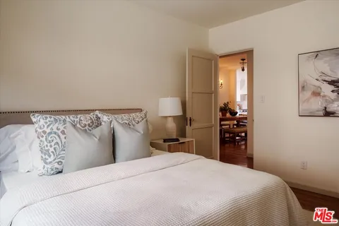 a bedroom with a bed and a painting on the wall