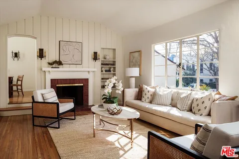 a living room with furniture a large window and a fireplace