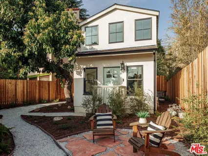 a front view of a house with a garden
