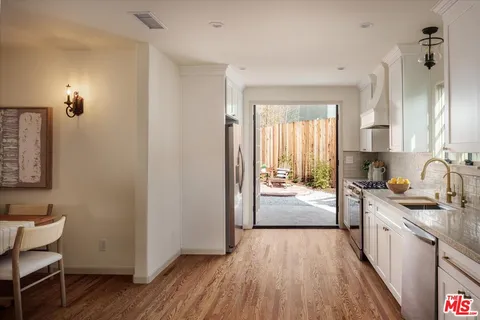 a kitchen with stainless steel appliances a window and wooden floor
