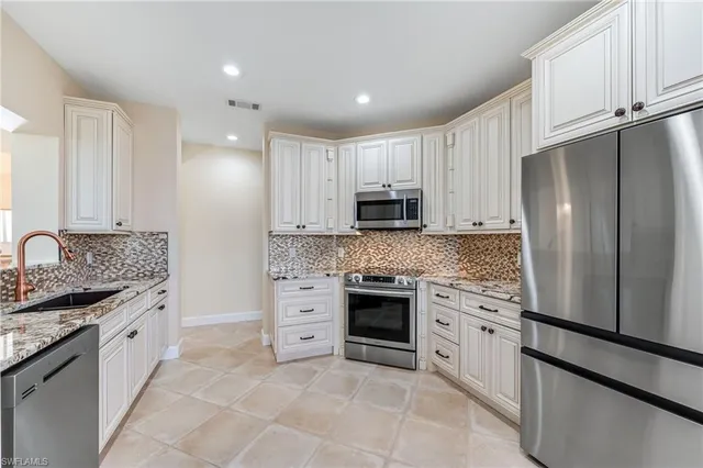 a kitchen with stainless steel appliances granite countertop a refrigerator sink and cabinets