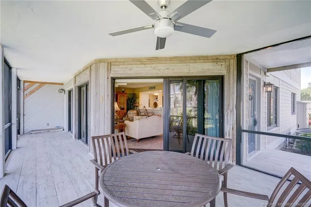 a dining room with furniture a chandelier and wooden floor